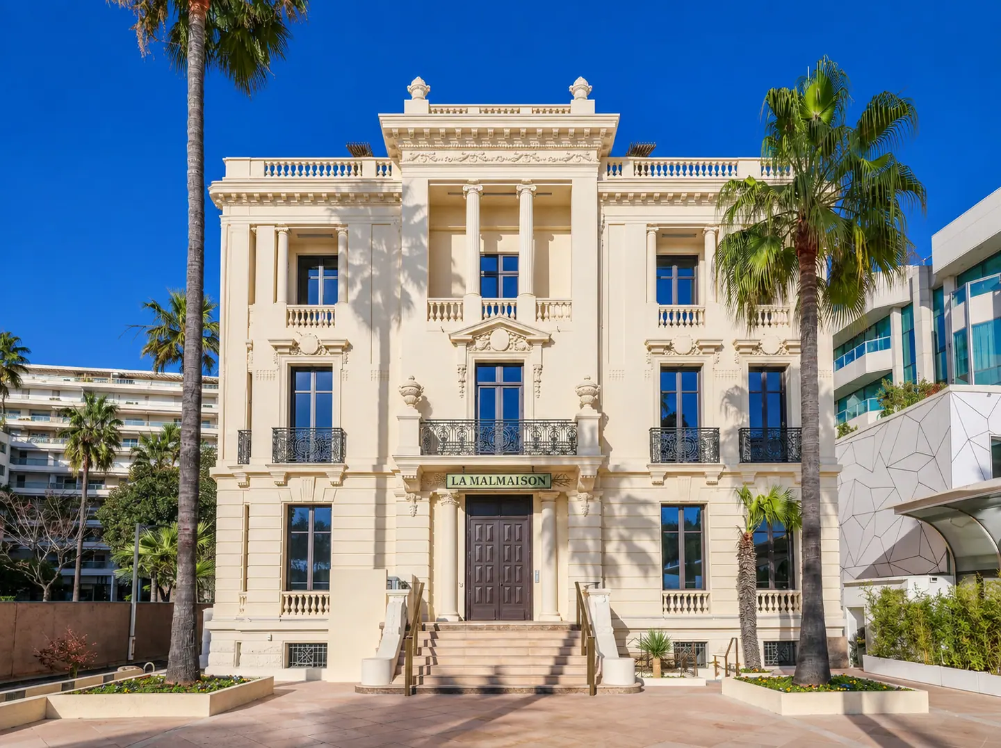 La Malmaison à Cannes, façade Belle Époque et ses menuiseries bois entre les palmiers