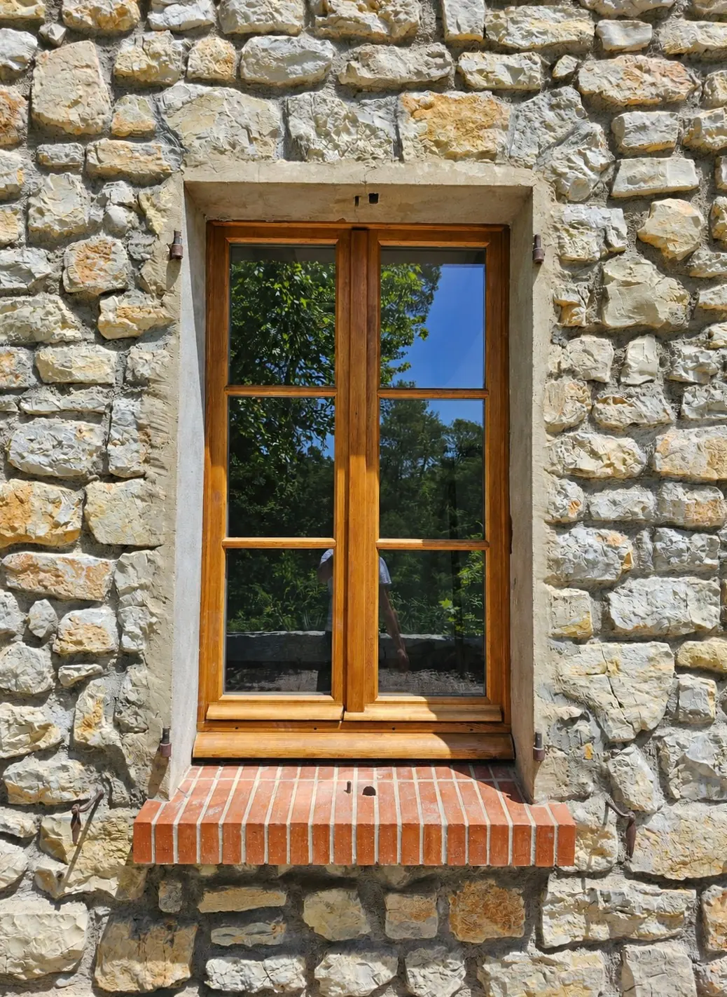 Fenêtre en chêne à petits-bois dans une façade de moellons