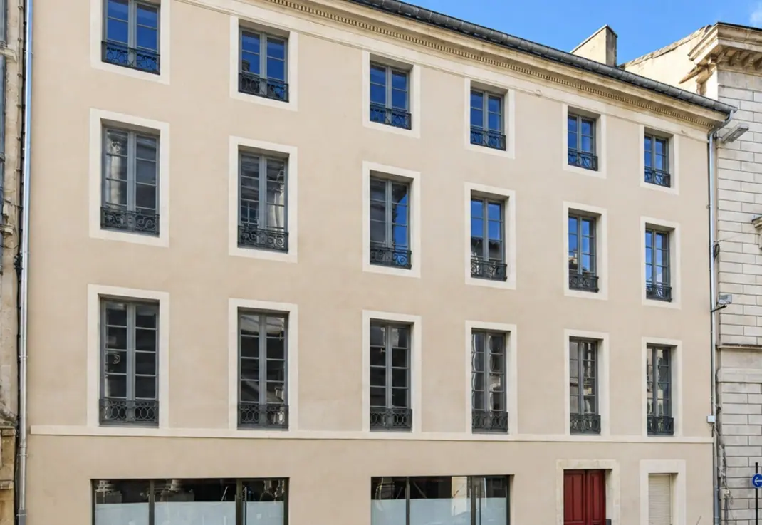 Grand immeuble en pierre du 12 Grand-Rue à Nîmes, fenêtres bois à petits-bois sur tous les niveaux