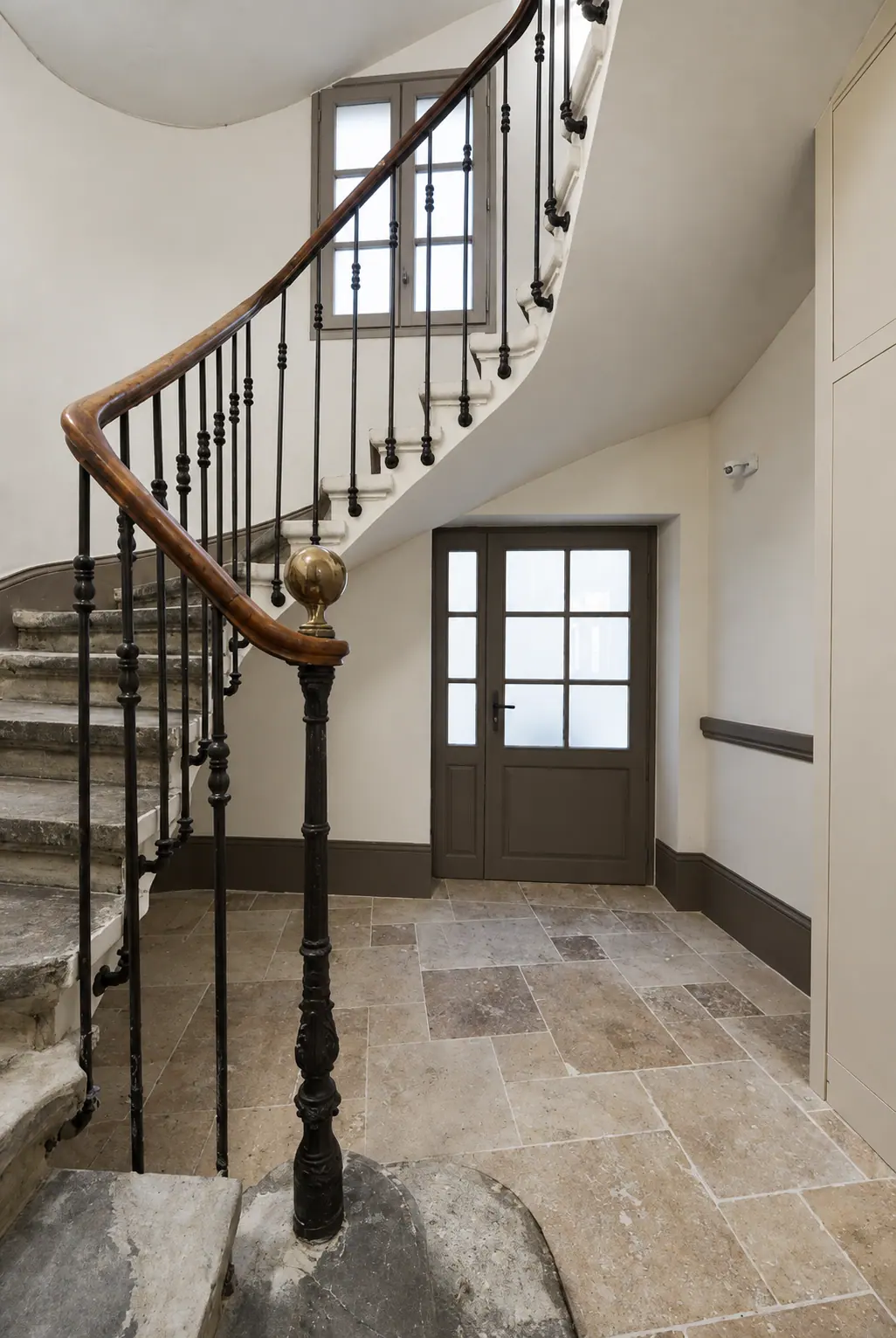 Escalier tournant à rampe en fer forgé et porte vitrée bois, 30 rue des Lombards à Nîmes