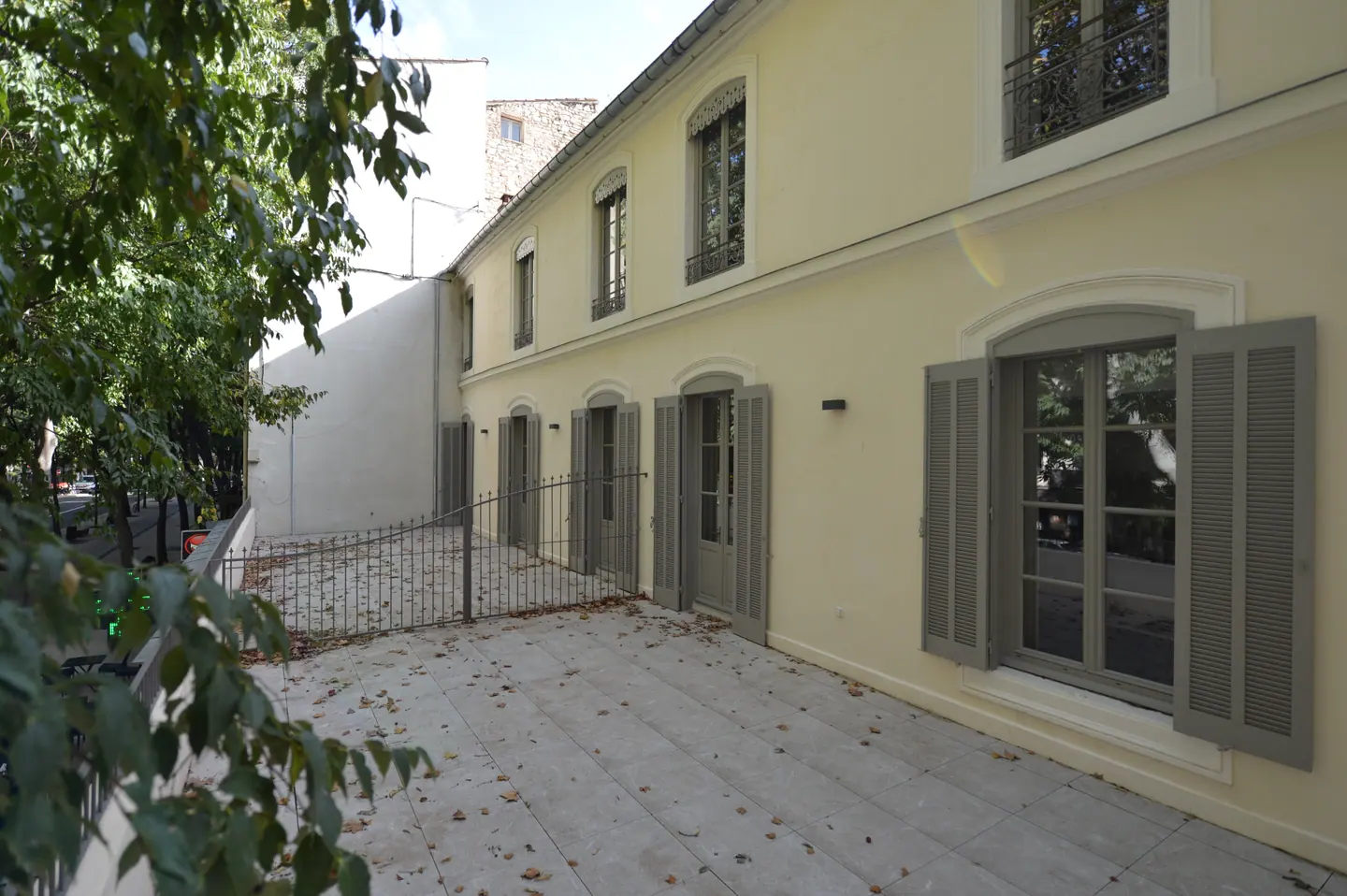 Façade sur cour du 30 rue des Lombards à Nîmes, fenêtres bois et volets battants gris