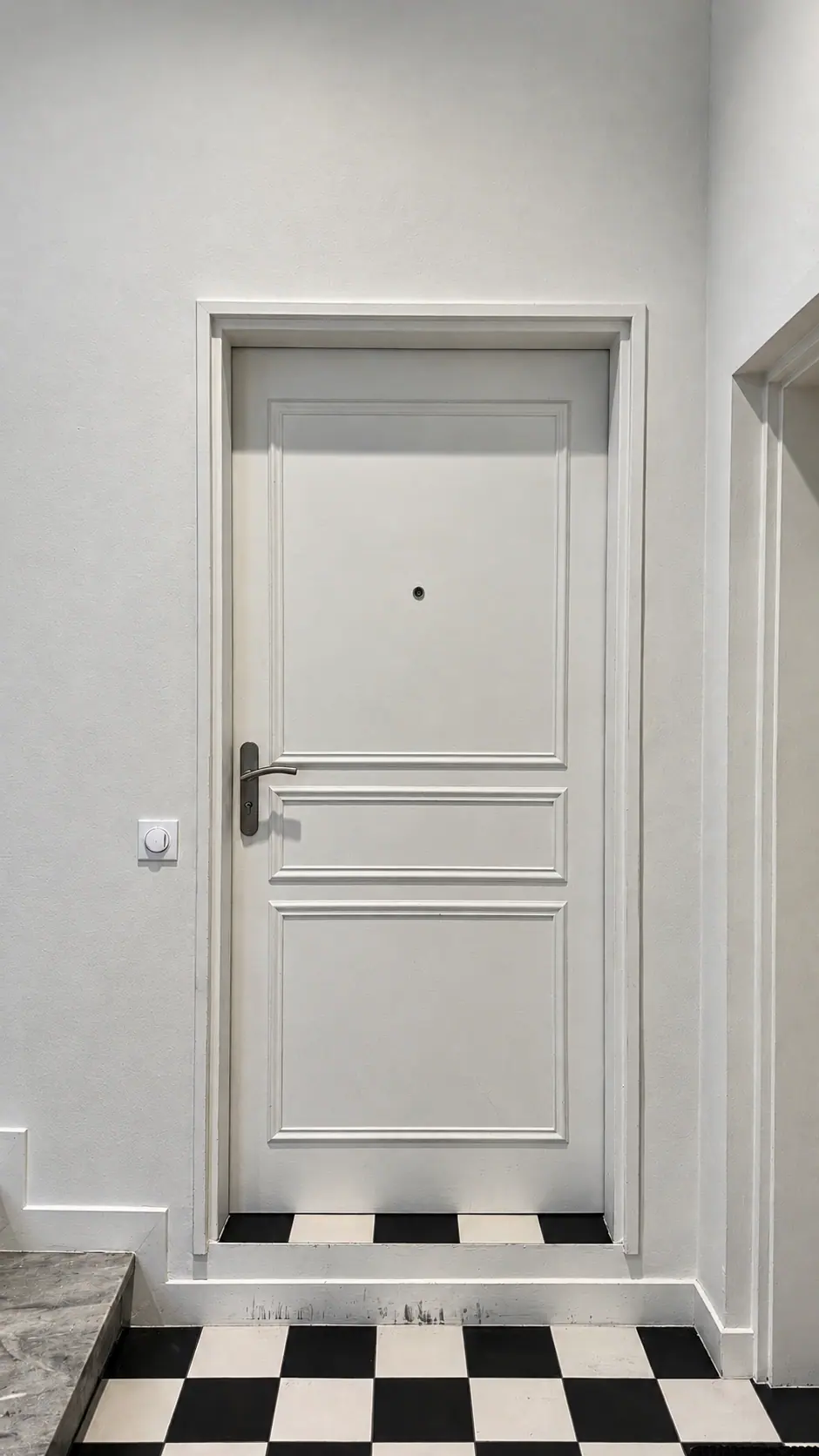Porte palière moulurée sur un sol en damier noir et blanc, villa du Trayas