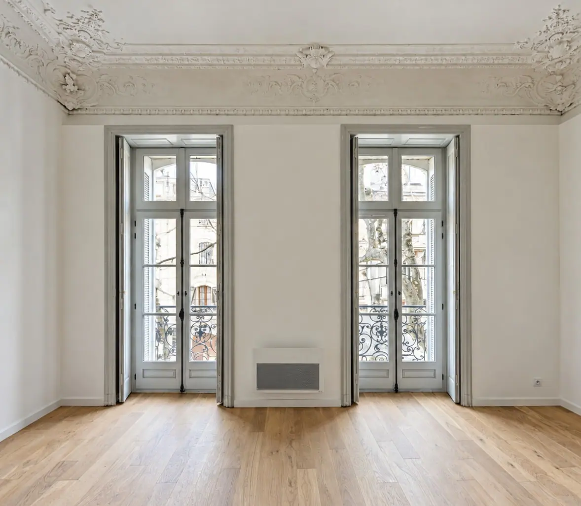 Salon aux moulures de plâtre éclairé par deux portes-fenêtres bois, Demeure Aquipierre à Uzès