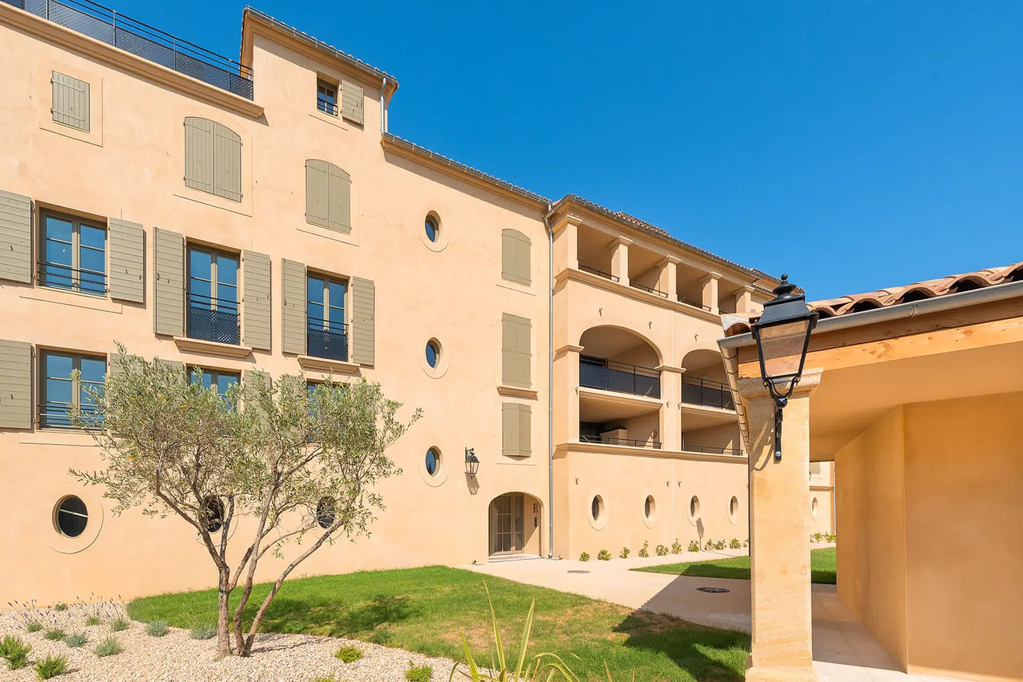 Résidence Les Terrasses du Paradis à Uzès : façades ocre, volets bois et jardin d'oliviers